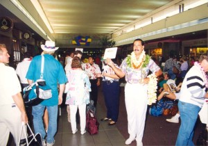 Photo of a greeter welcoming an arriving passenger to Honolulu