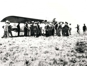 A crowd gathers around the Dole Derby winner Woolaroc after it came to a stop at Wheeler Field's grassy runway, August 16, 1927. 