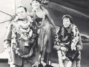 Hula dancer Dorothy Leslie posed between George Putnam, publisher and husband of Amelia Earhart, right, on arrival in Honolulu, December 27, 1934.  