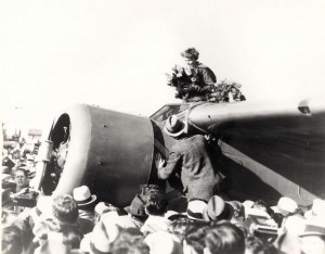 Amelia Earhart receives a bouquet in the cockpit of her plane after landing at Oakland Field, California, on January 12, 1935 after her flight from Hawaii.  