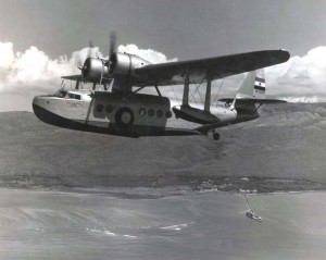 Inter-Island Airways c1936-1939. Plane sweeps over tiny village of Kaunakakai, Molokai.