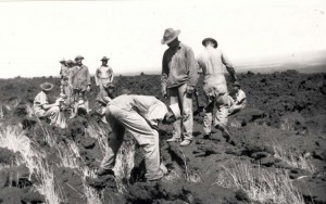 Detail is prepping a site on a lava flow at Morse Field, Hawaii, to lay out a 100-foot diameter circle for a bomb target. Cans of water and bags of lime were taken 700-feet down a goat path carried on the backs of the men, c1940-1941. 