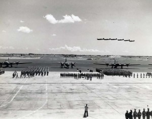 Mass awards ceremony at Hickam Field in which 7th Air Force awarded medals to fliers who participated in Battle of Midway. Flying overhead are P-40E aircraft. Parked on flight line are B-17s on each side of a Martin B-26, September 17, 1942.   