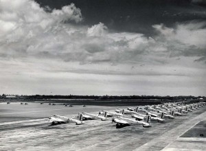Fast pursuit planes take off as giant bombers prepare to follow at Hickam Field.  