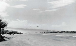 Four Bell P-39s fly over Haleiwa Field as maintenance work progresses at left, September 1945. 
