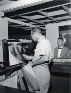 U.S. Health Inspector reads an x-ray before admitting traveler into the U.S. at Honolulu International Airport, 1950s. 
