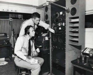 Hawaiian Airlines pilots at Honolulu International Airport listen to weather information before their flight, 1950s. 