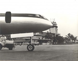 Historic photo of a nose of the aircraft with the HNL tower in the background