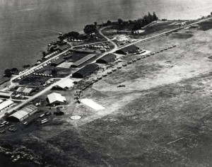 Luke Field on Ford Island with DH-4 and JN-4/6 aircraft lined up. At lower left are aircraft packing crates. Round spot on field is compass rose, 1919-1921.     