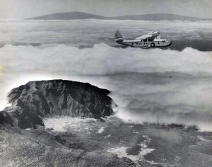 Inter-Island Airways November 2, 1935. U.S. mail flying over Haleakala on Maui, with Mauna Loa and Mauna Kea on the Big Island in background.