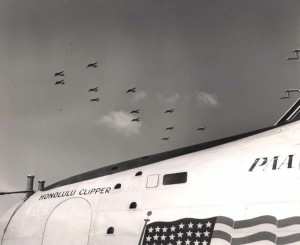 Army patrol planes fly over the Pan American Honolulu Clipper during ceremonies in which the flying boat was christened in honor of America's most westerly city. 1939  