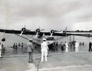 Pan American Clipper ship is assisted into hangar at Pearl Harbor by sailors.  
