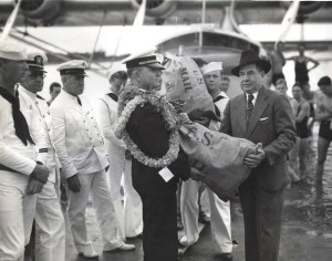 R.O.H. Sullivan, executive officer of Pan American Clipper, hands the first sack of air mail to John H. Wilson, U.S. Postmaster at Honolulu. April 20, 1935.  