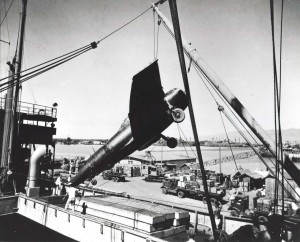New fighter aircraft (P-47 Thunderbolt) being unloaded at Pearl Harbor in 1942 for delivery to Hickam Field where it would be assembled and prepped for flight. 