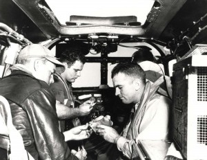 Inside B-18 over Hawaii a message on onion skin paper is placed in a capsule and attached to a carrier pigeon's leg before the bird is tossed out, January 1943. 