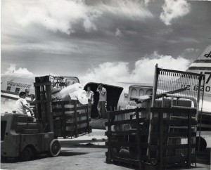 Cargo is loaded onto a Hawaiian Airlines plane at Honolulu International Airport, 1950s.