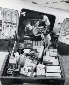 Hawaiian Airlines cargo is loaded aboard a plane at Honolulu International Airport, 1950s.