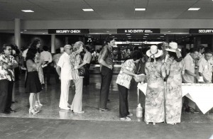 Visitor Information Program staff assist passengers through security checkpoint at Honolulu International Airport, 1980s. 